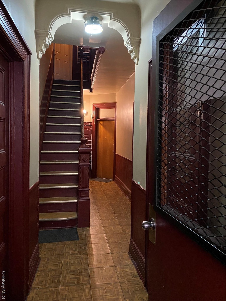 Staircase with wainscoting and wooden walls