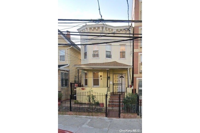 View of front facade with a fenced front yard and covered porch
