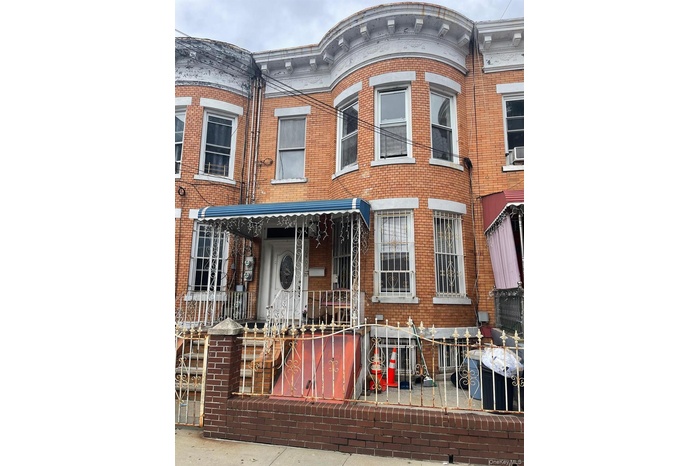 View of front facade featuring brick siding and covered porch
