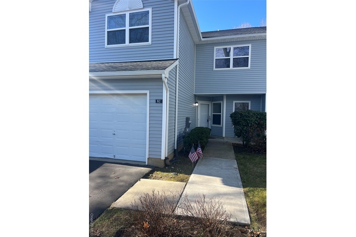 Traditional-style home featuring roof with shingles and a garage