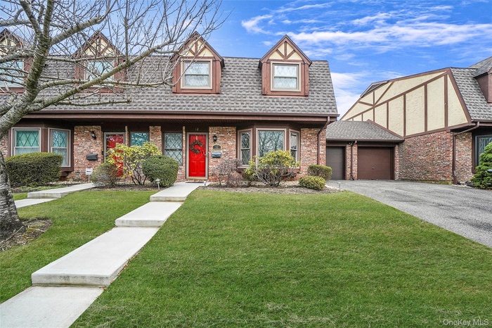 Tudor style townhouse with a garage, asphalt driveway