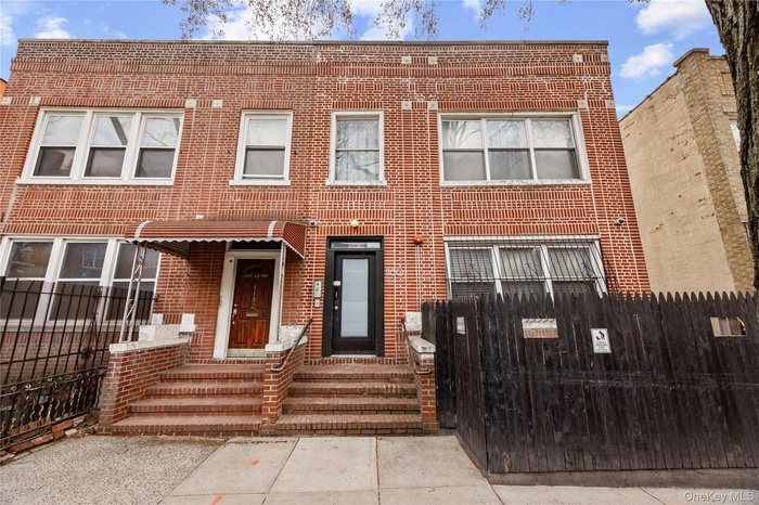 View of front of home featuring a fenced front yard and brick siding