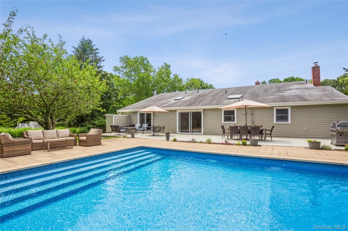 Outdoor pool featuring a patio area, an outdoor living space, outdoor dining space, and grilling area