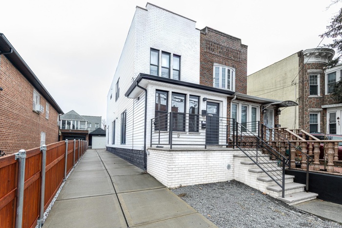 View of front of home featuring brick siding and an outdoor structure