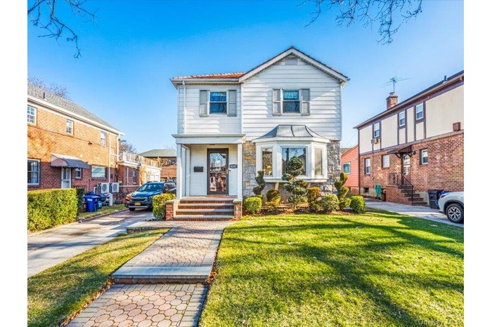 Traditional home with a front lawn and stone siding