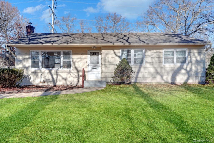 Single story home featuring a front yard and a chimney