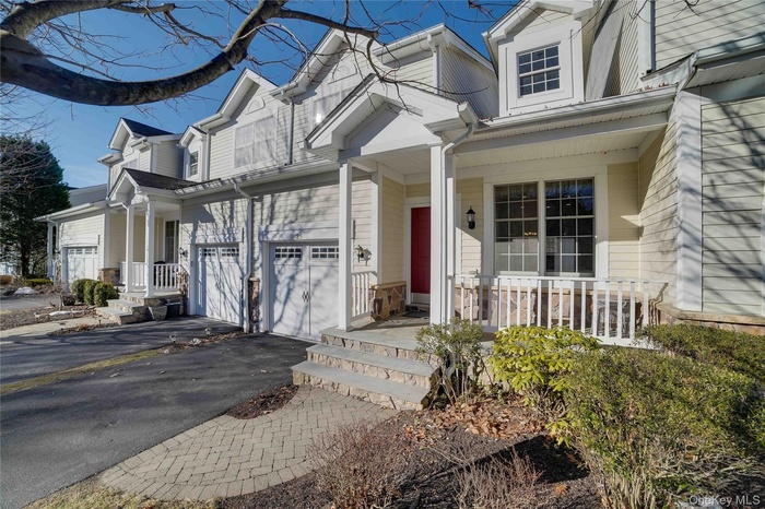 View of front of house featuring driveway, a garage, and covered porch