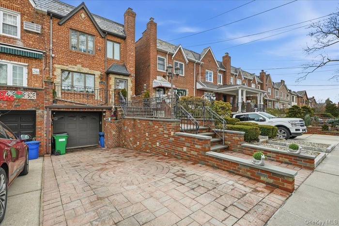 View of front facade featuring a residential view, brick siding, a garage, and driveway