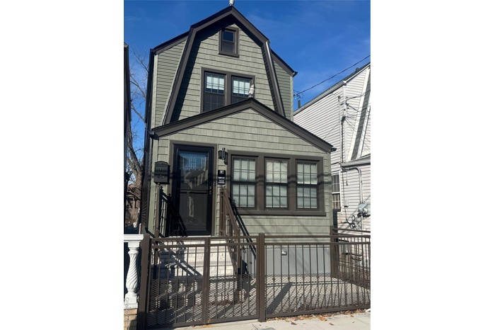 View of front of house with a gambrel roof, a fenced front yard, and a gate