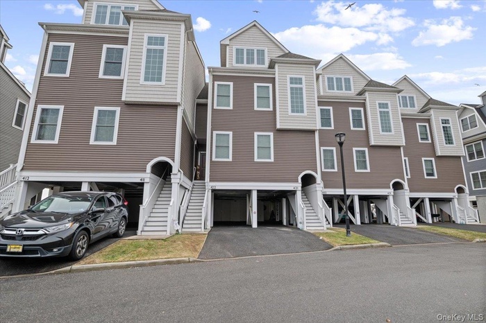 View of front of home featuring a residential view, driveway, and stairway