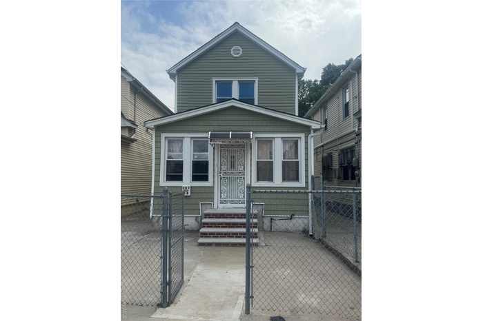 View of front of property featuring a gate and a fenced front yard