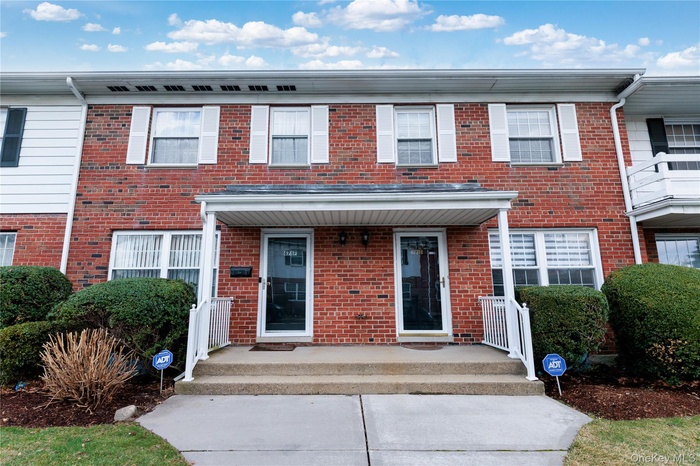 View of front of house with brick siding and covered porch