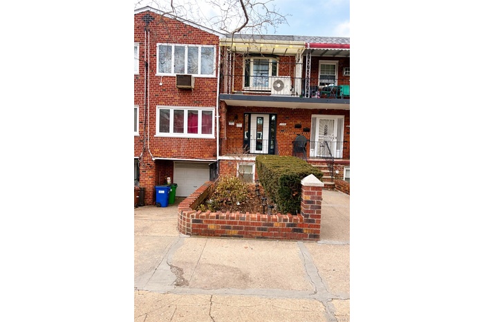 View of front of house with brick siding, concrete driveway, a balcony, covered porch, and an attached garage
