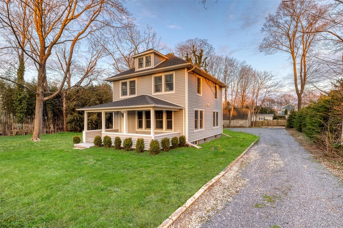 Traditional style home featuring covered porch, driveway, a shingled roof, and crawl space