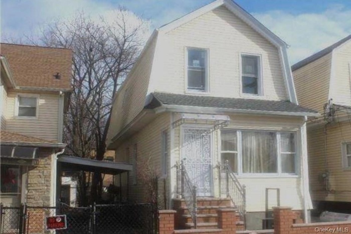 Dutch colonial with a gambrel roof, a gate, and a fenced front yard