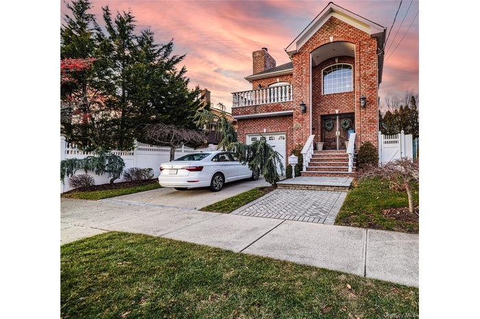 Traditional home featuring driveway, a chimney, and brick siding
