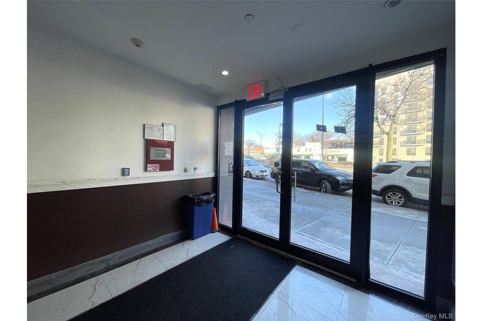 Doorway to outside with marble look tile flooring and recessed lighting