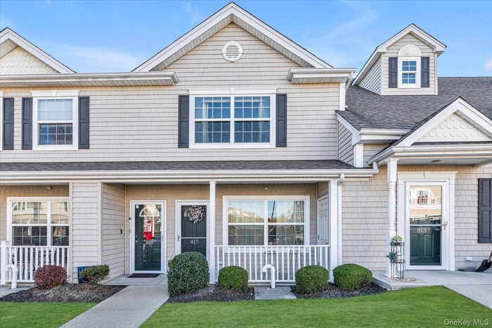 View of front of home featuring a shingled roof, a front yard, and a porch