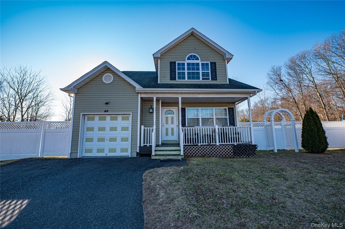 Traditional-style home featuring a porch, asphalt driveway, and a shingled roof