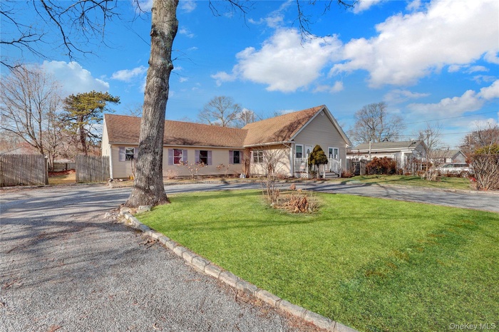 Ranch-style home featuring asphalt driveway and a shingled roof