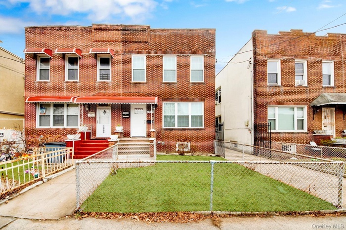 Traditional-style house with brick siding and a fenced front yard