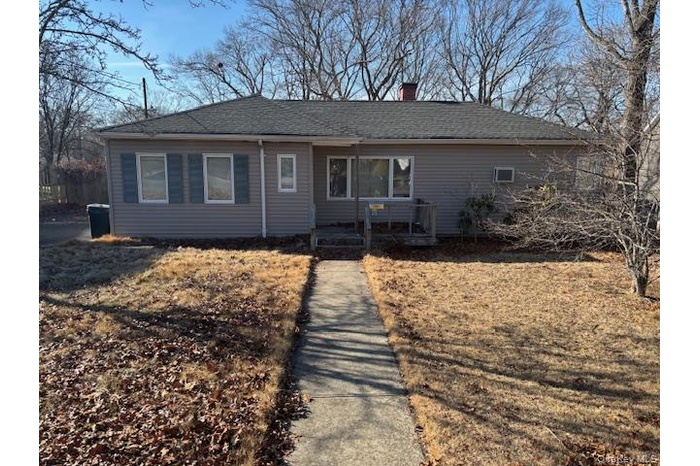 Single story home with a chimney and roof with shingles