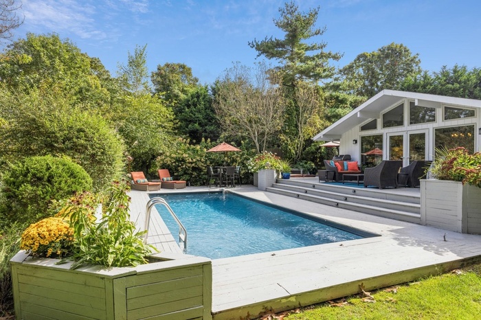 View of pool with a patio, an outdoor structure, an outdoor hangout area, and a wooden deck