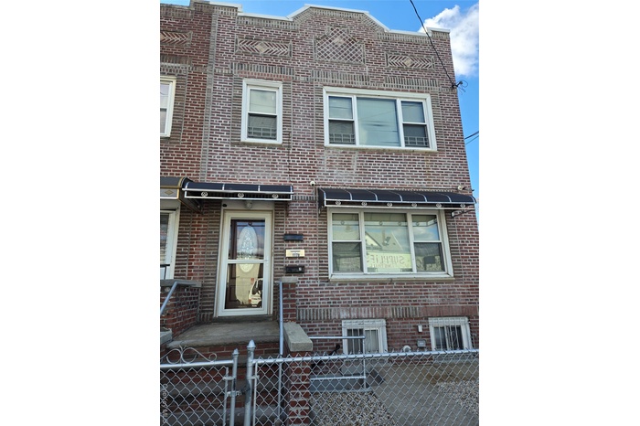 Traditional-style house with brick siding and a fenced front yard