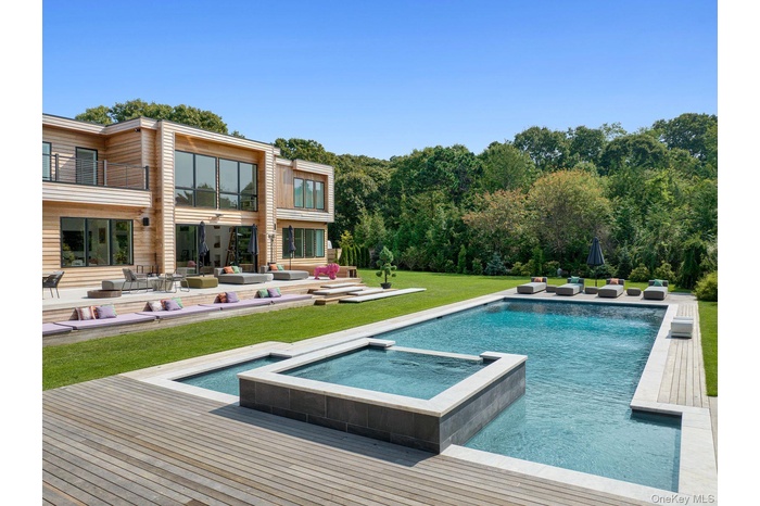 View of pool featuring a lawn and a pool with connected hot tub