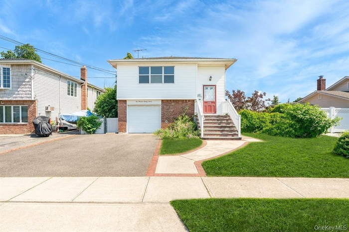 View of front of house with brick siding, asphalt driveway, and a garage