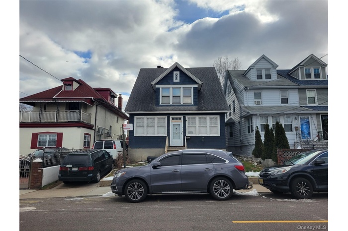 View of front of home with a residential view, roof with shingles, and a chimney