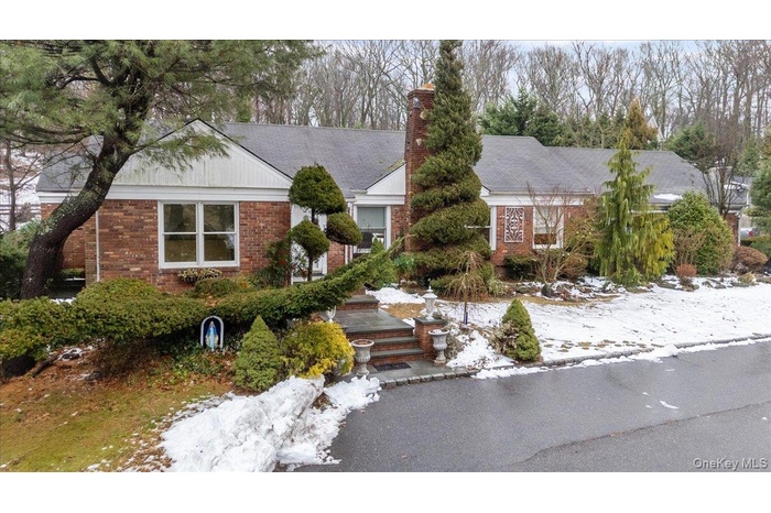 View of front of home with brick siding and a chimney