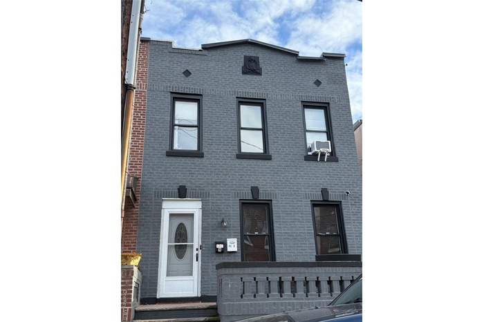 View of front of house featuring brick siding and cooling unit