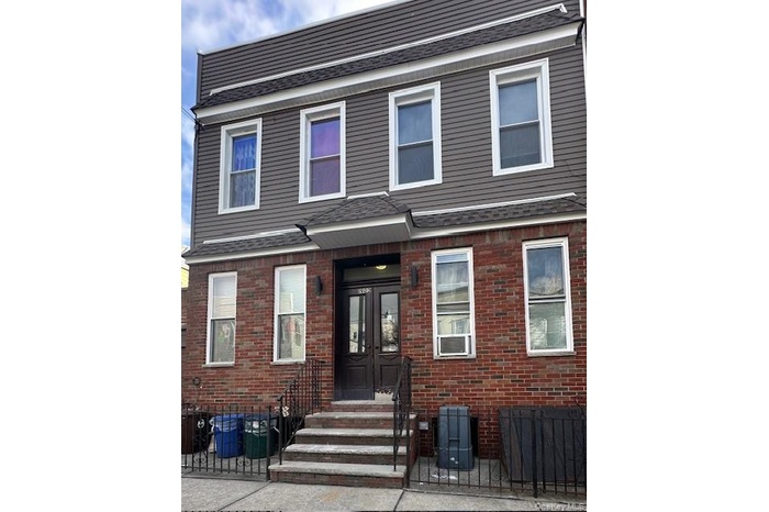 Traditional-style house with brick siding, a patio area, and french doors