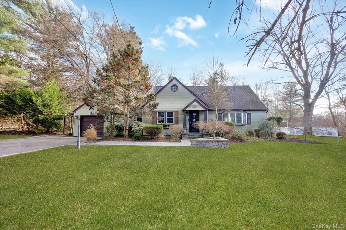 Ranch-style home with a front lawn and asphalt driveway