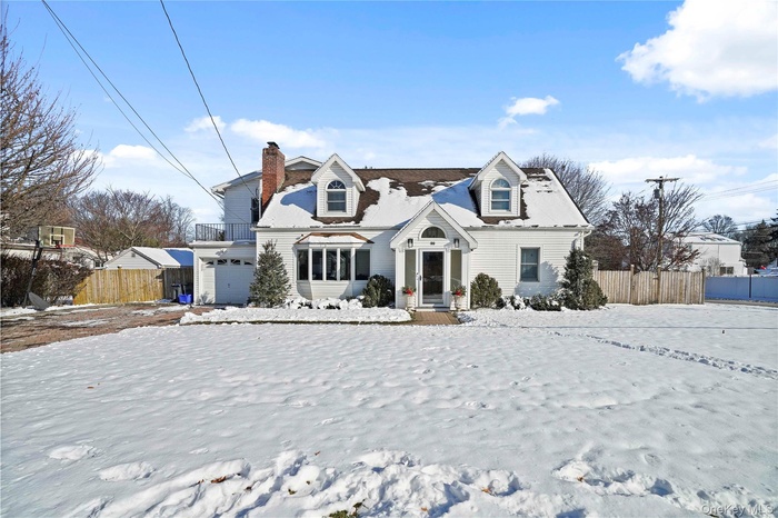 Cape cod-style house with a chimney and a garage