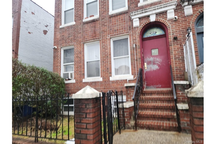 View of exterior entry featuring brick siding and a gate