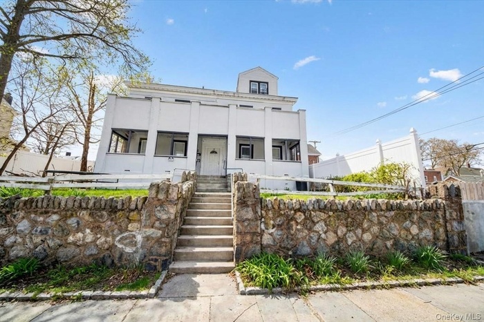View of front of property featuring a fenced front yard, stairway, and stucco siding