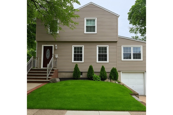 Colonial house with a front yard and a garage