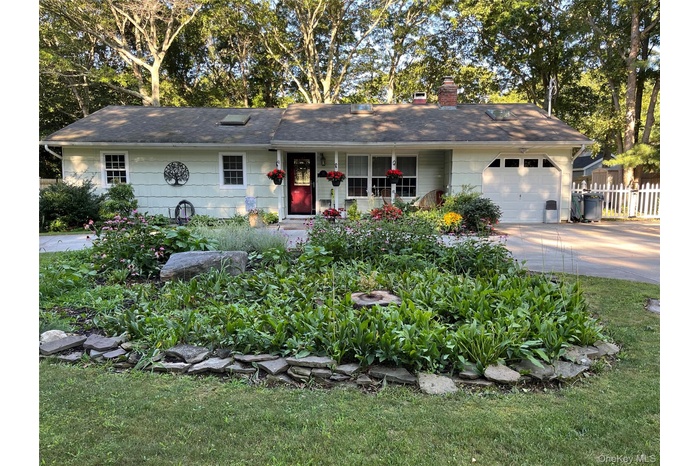 Ranch-style house with a chimney, an attached garage, concrete driveway, and a porch
