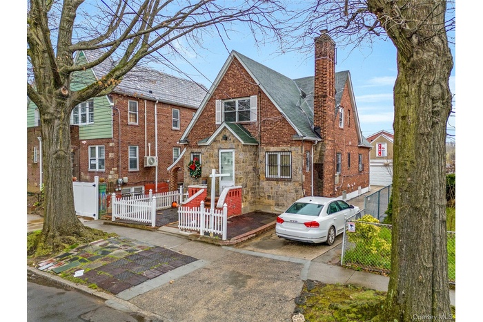 Tudor-style house with a chimney and brick siding