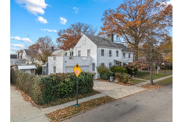 View of home's exterior featuring a chimney and driveway