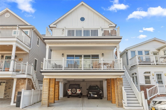 View of front of home with stairs, board and batten siding, a carport, concrete driveway, and a garage
