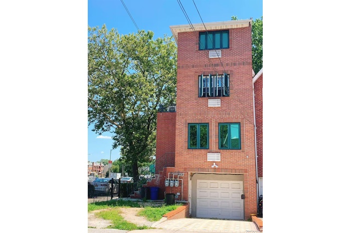 View of front facade with brick siding, driveway, and an attached garage