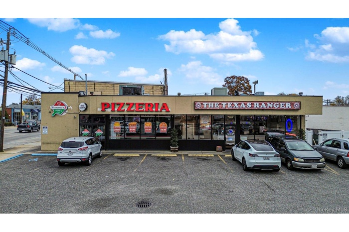 View of commercial property with uncovered parking