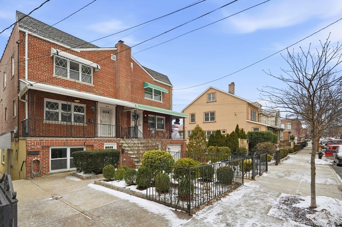 View of front facade with brick siding, a residential view, and stairway