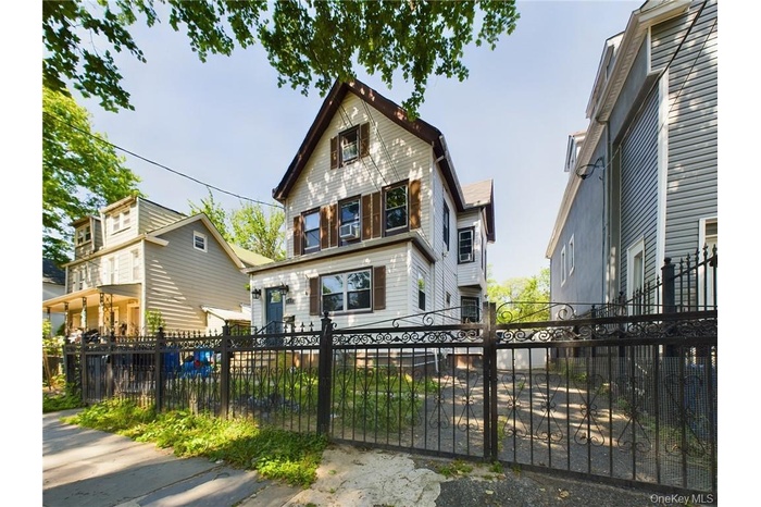 View of front of house with a fenced front yard and a gate