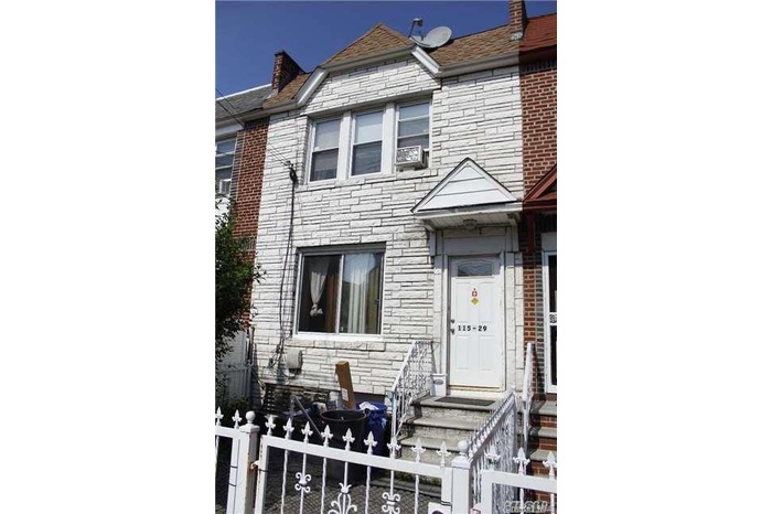 View of front of home featuring a fenced front yard and stone siding