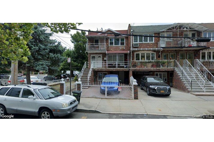 View of front of house with stairway, a fenced front yard, brick siding, and a balcony