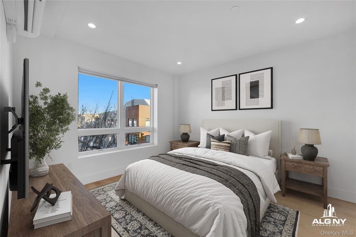 Bedroom featuring wood finished floors, a wall mounted AC, and recessed lighting
